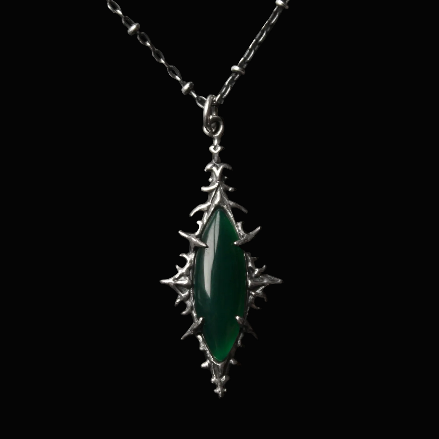 Green pendant necklace on a dark textured background